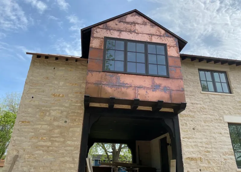 Copper metal panel facade on a stone building for Metal Roof Coating in Uhrichsville